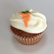 Cinnamon, carrot, sliced almond kake with cream cheese buttercream frosting decorated with a cream cheese buttercream frosting carrot.